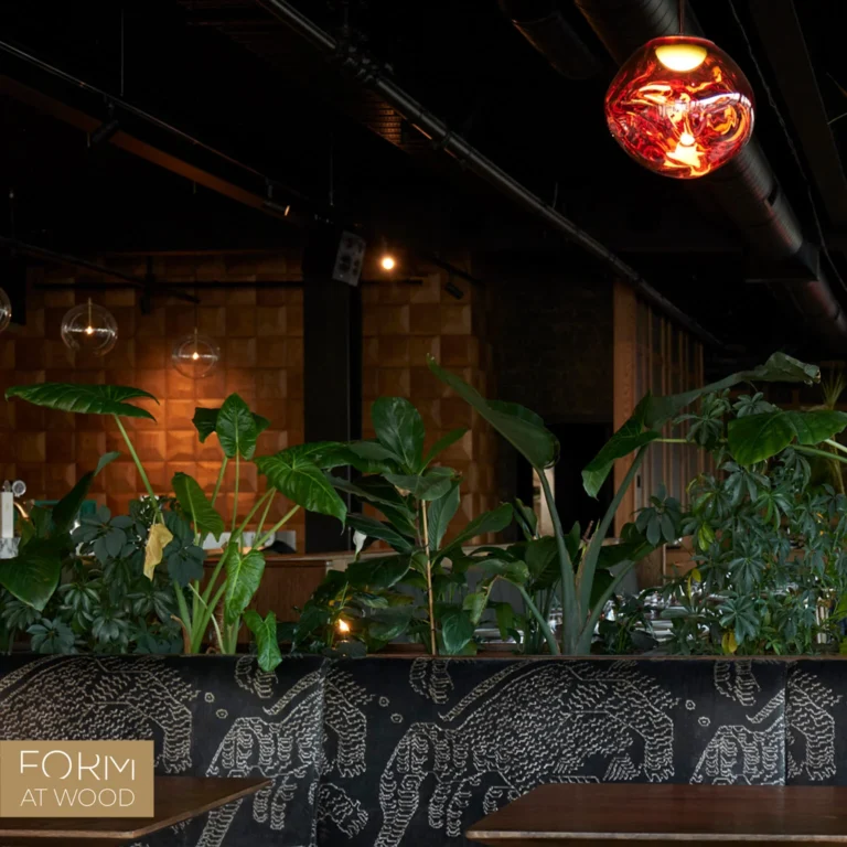 Restauracja z roślinnością i ścianą z drewnianych paneli