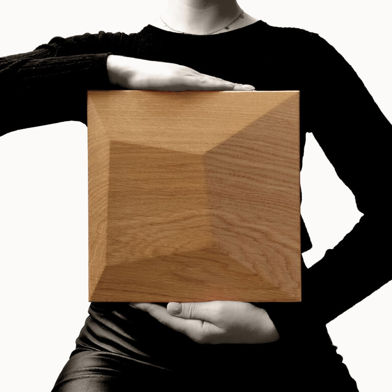 Wooden wall panel held in hand, showing material finish