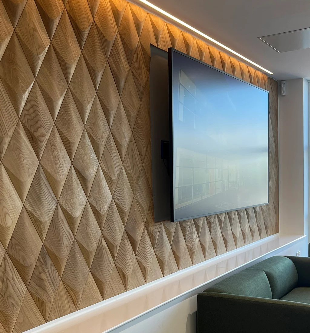 Moderne TV-Wandgestaltung mit 3D-Holzpaneelen aus Eiche in Rautenform mit integrierter LED-Deckenbeleuchtung.