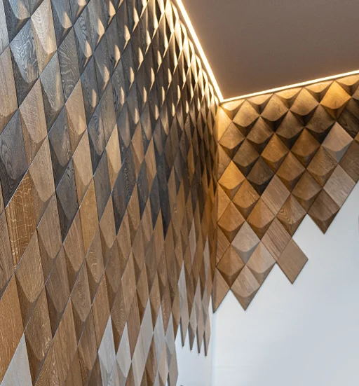 Moderne Wandinstallation aus 3D-Eichenholzpaneelen in Diamantform z mit linearer LED-Beleuchtung an der Decke.