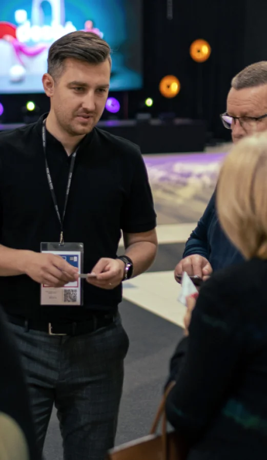 A representative of a 3D oak panels manufacturer engaging in a business conversation with clients at an interior design trade fair.