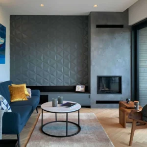 Modern living room interior featuring dark grey geometric 3D wooden wall panels next to a contemporary concrete fireplace.